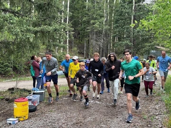 Laufgruppe bewegt sich gemeinsam über einen Waldweg